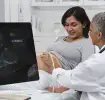 Mujer embaraza en estudio con médico obstetra