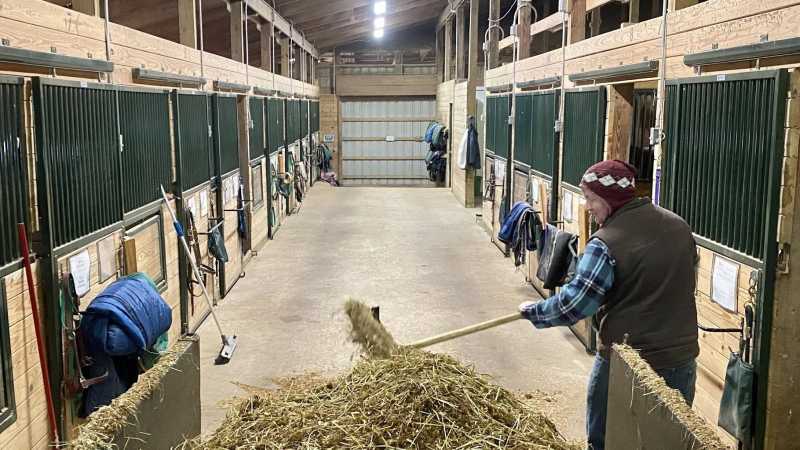 Stable Supervisor Xander Hull loads a tractor during stall cleaning