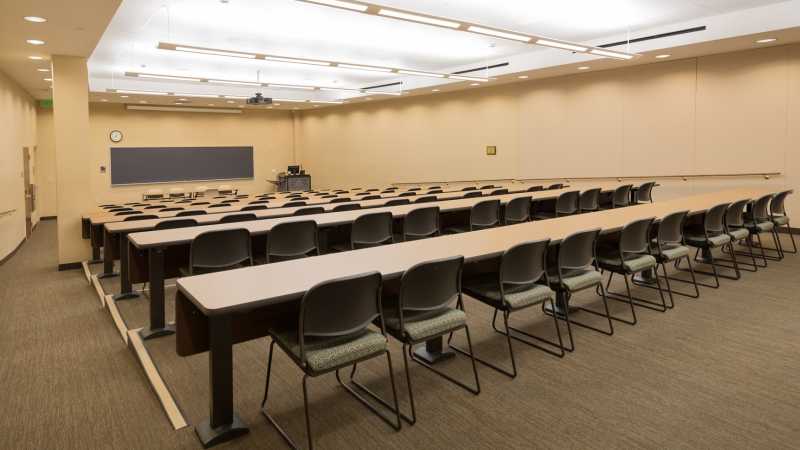 Photo of a large auditorium with long tables and chairs.