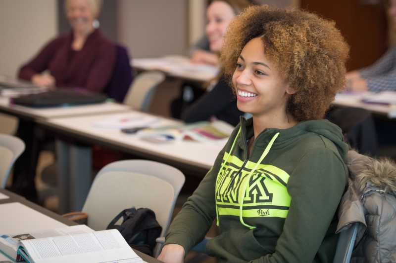 graduate student wearing a green hoodie in a lake erie college classroom