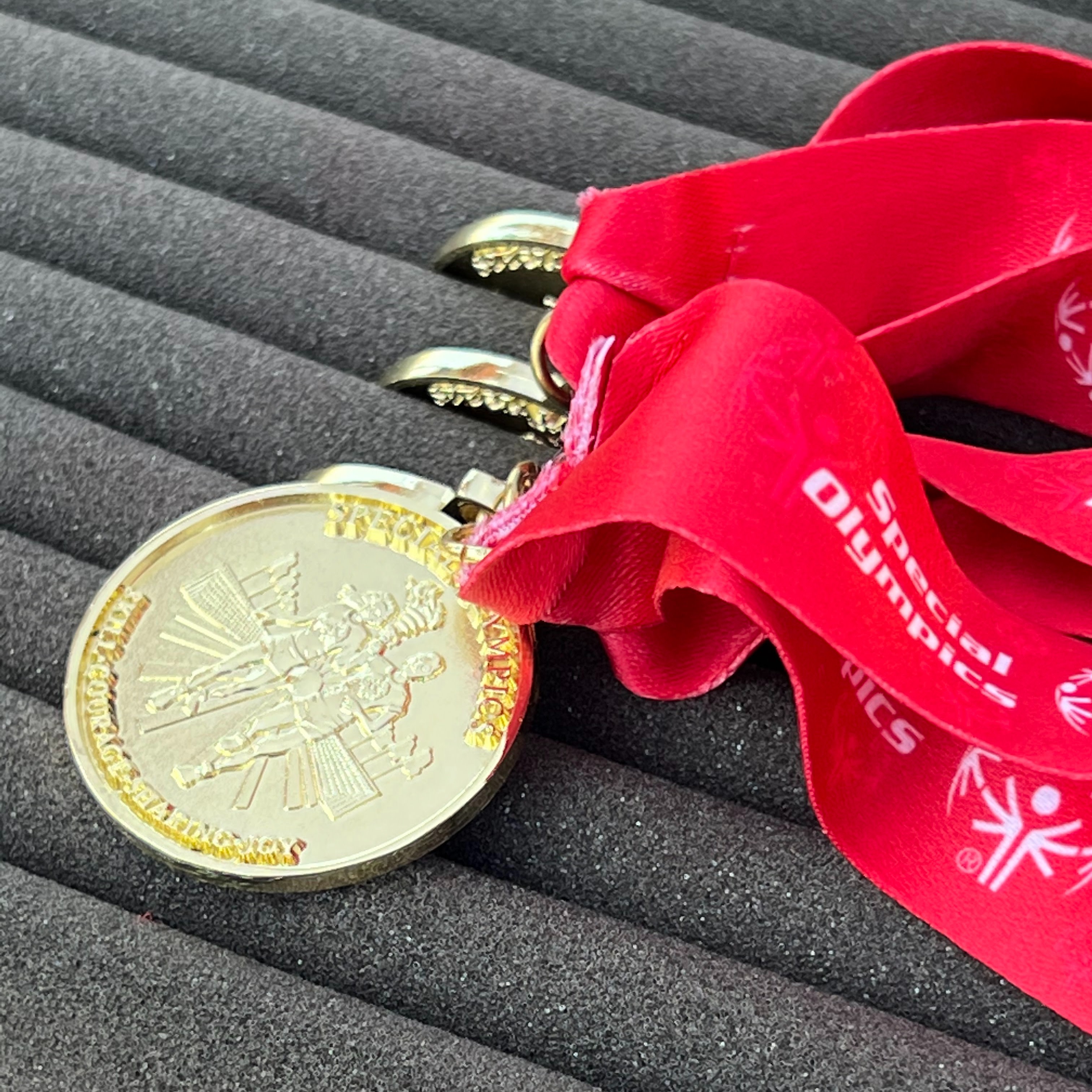 Photo of gold medals on red ribbons