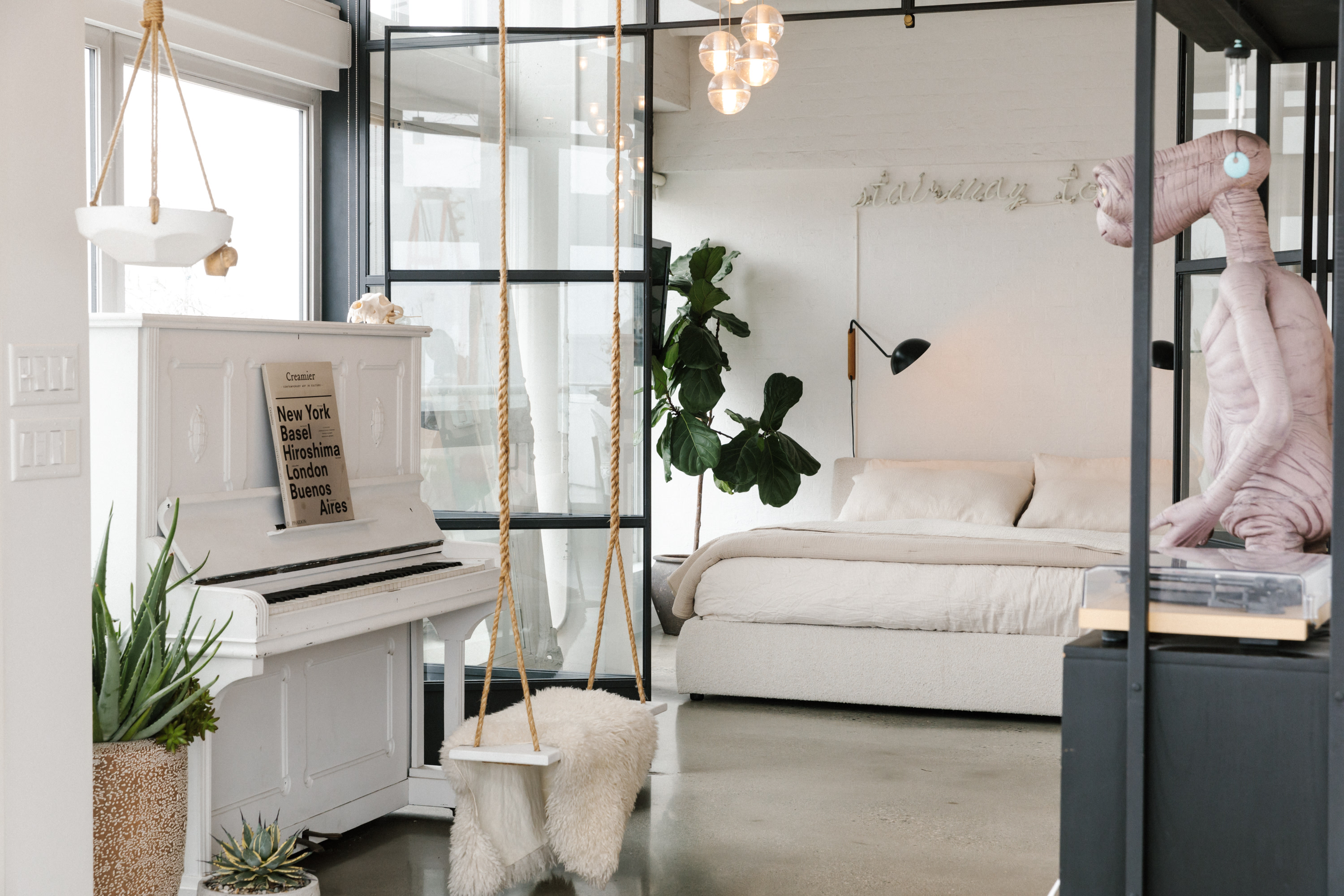 Beautifully staged bedroom with unique bulb light fixture.