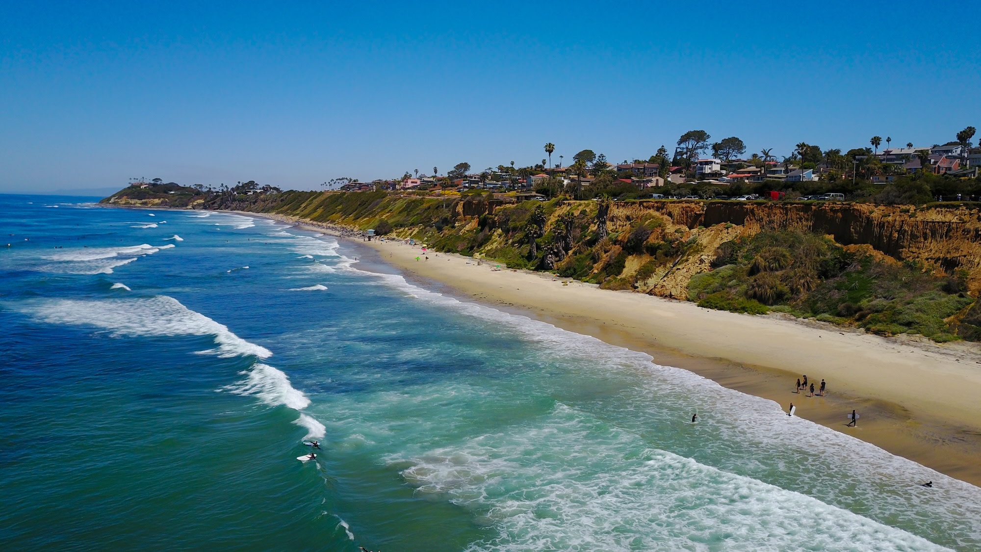 Photo of the expansive beach and ocean in Encinitas with cliffs topped by houses in the background