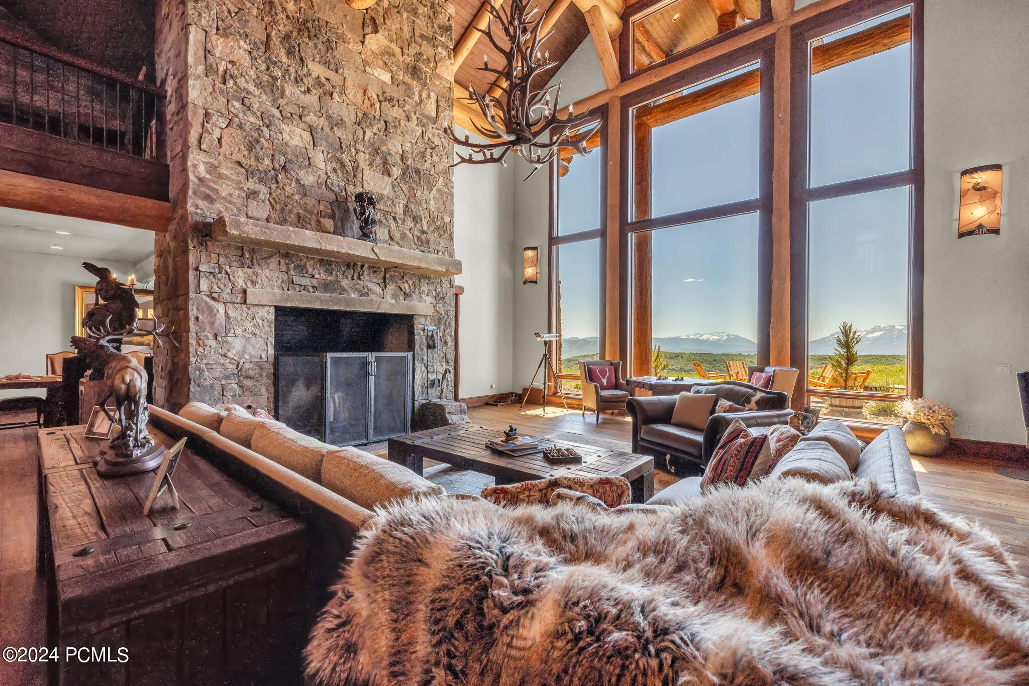 Interior of luxury ranch home, fur blanket, stone fireplace.