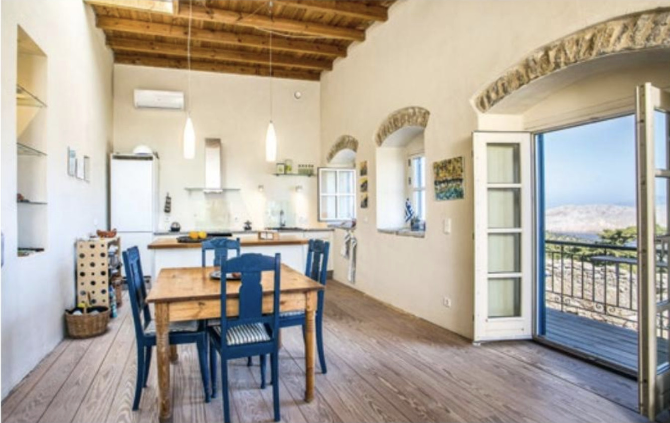 Dining room with blue chairs and an open door 