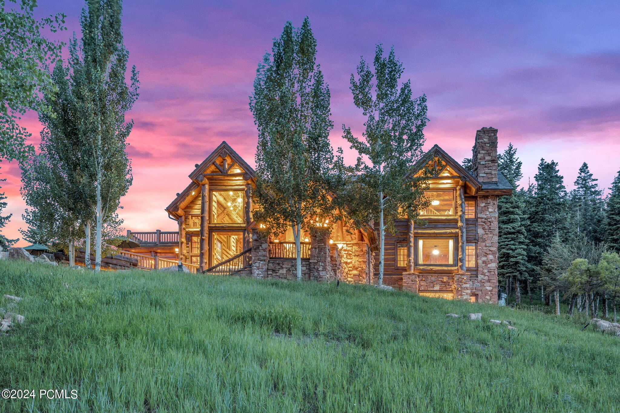 Stone cabin with colorful sunset in background.