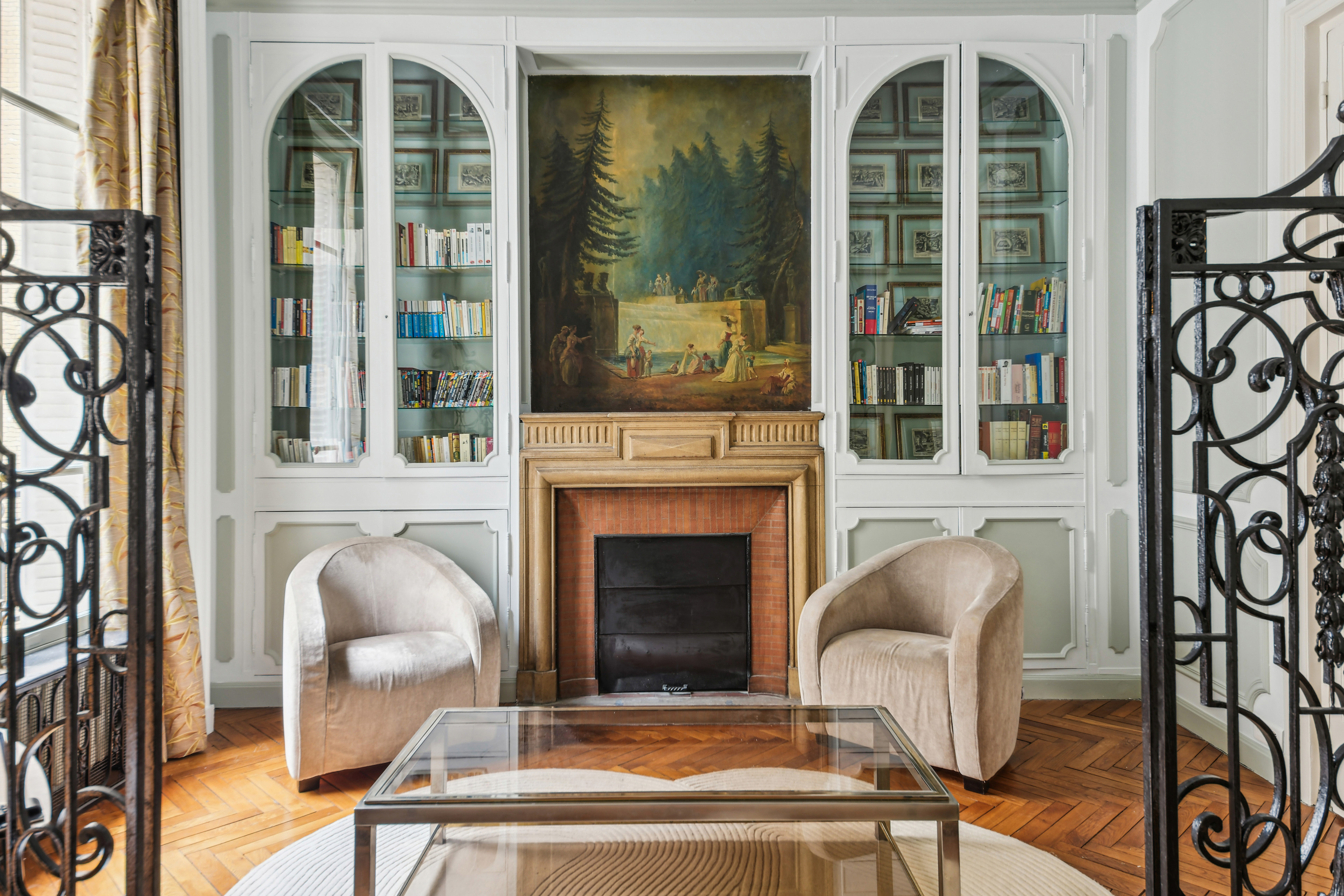 Paris living room with fireplace and glass cabinets.