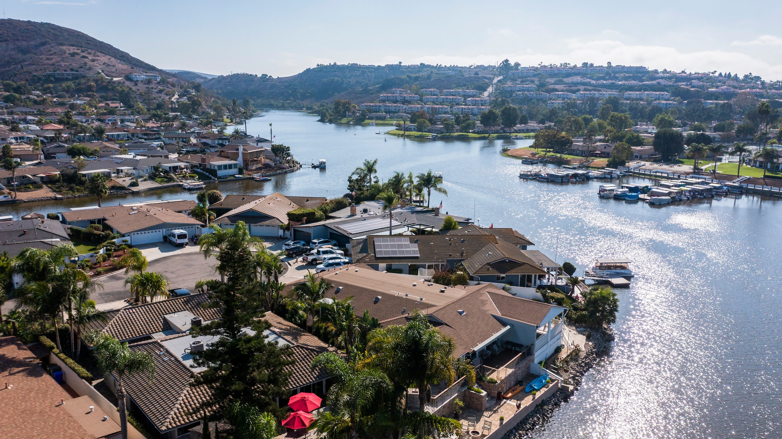 Photo of the overhead view of houses surrounding Lake San Marcos with hills in the background