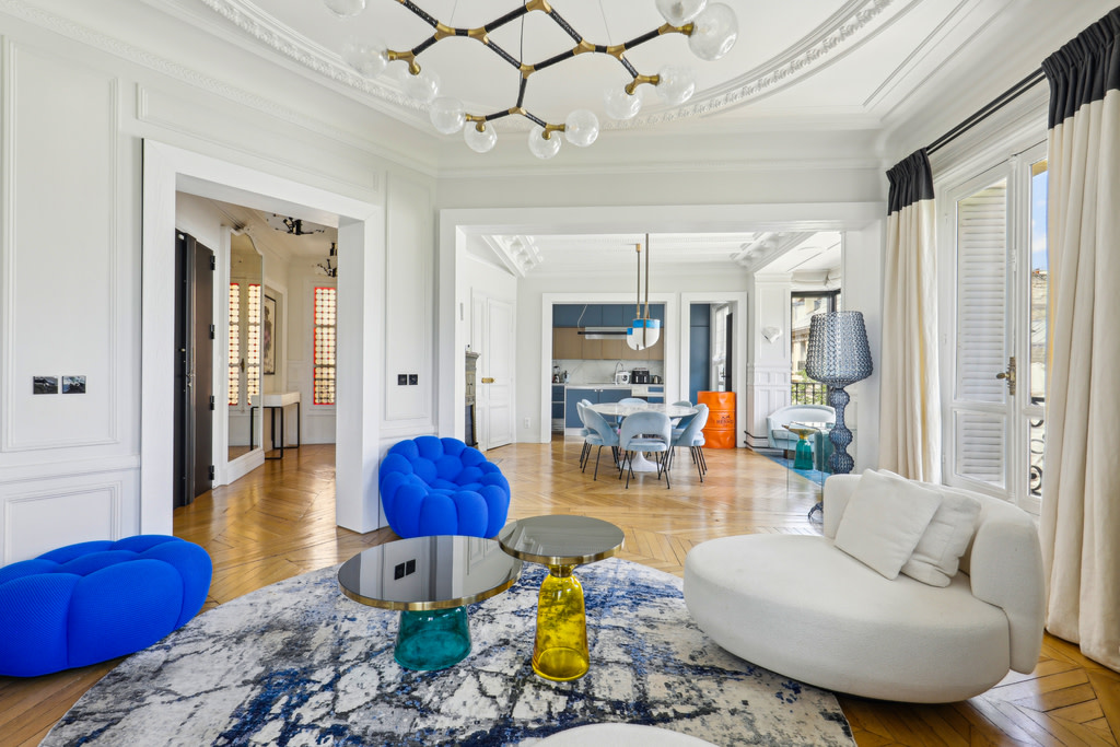 Luxury modern living room with vibrant blue chairs and large doorways.