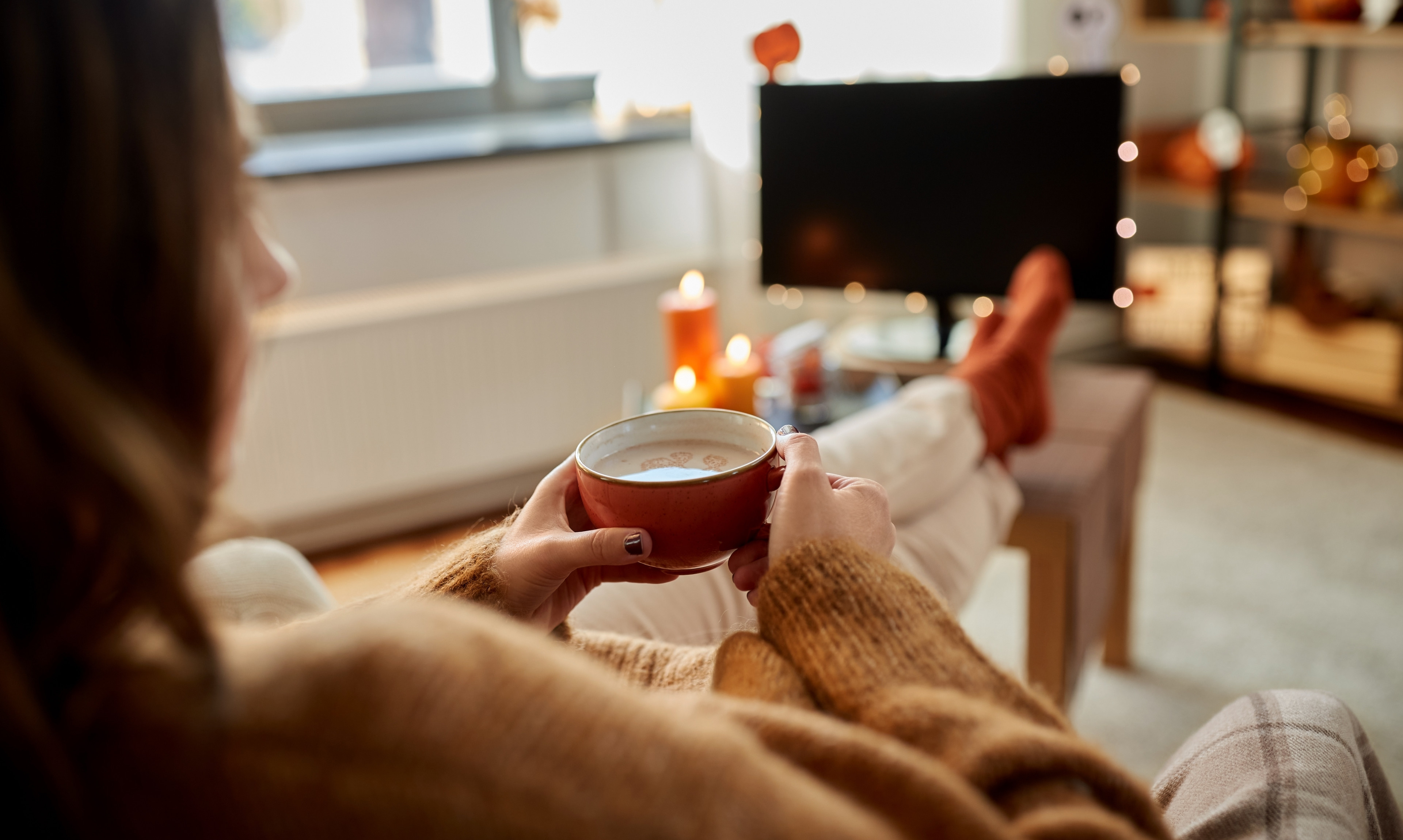 Girl sitting with latte and warm socks. 