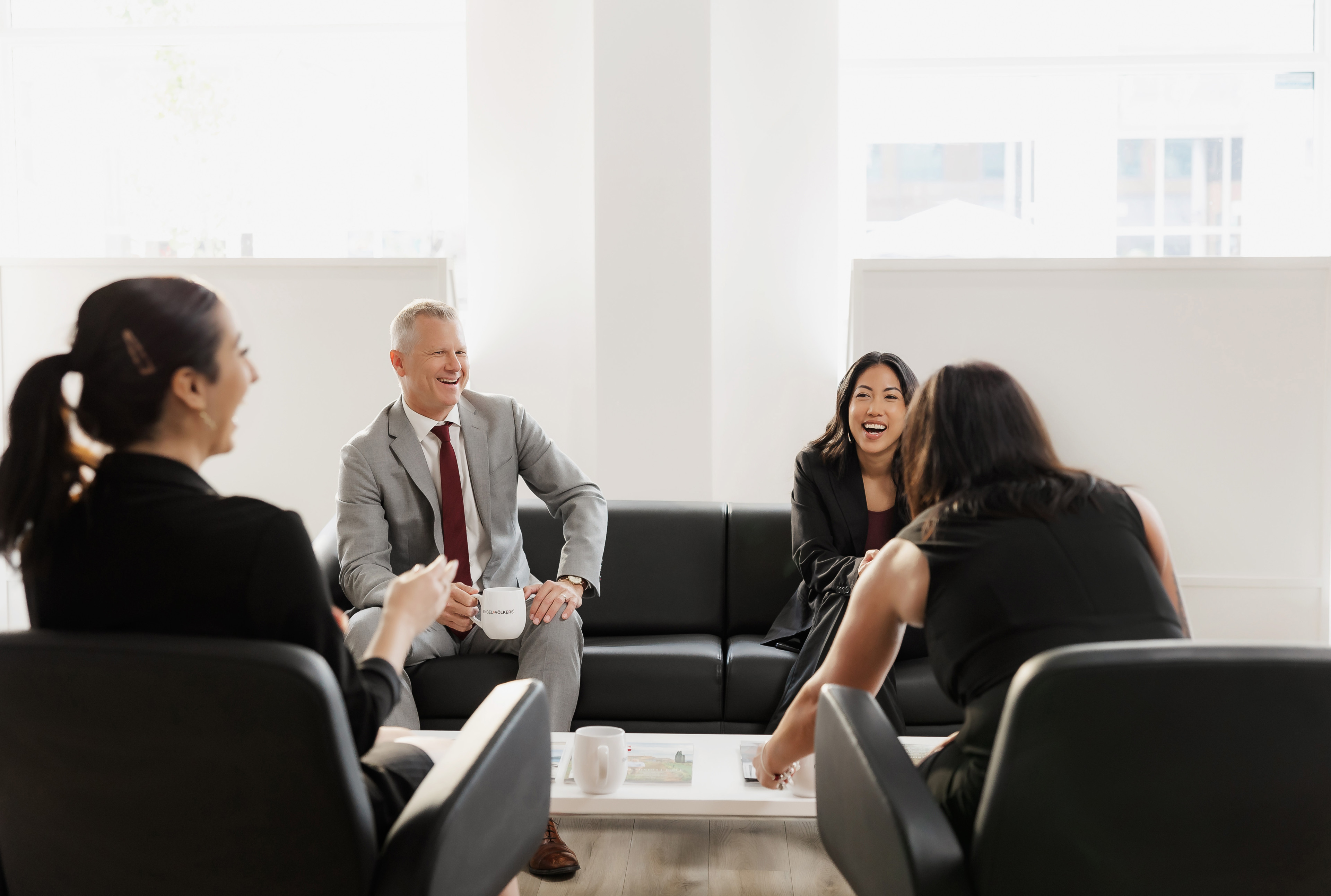 Photo of a group of people smiling and discussing business