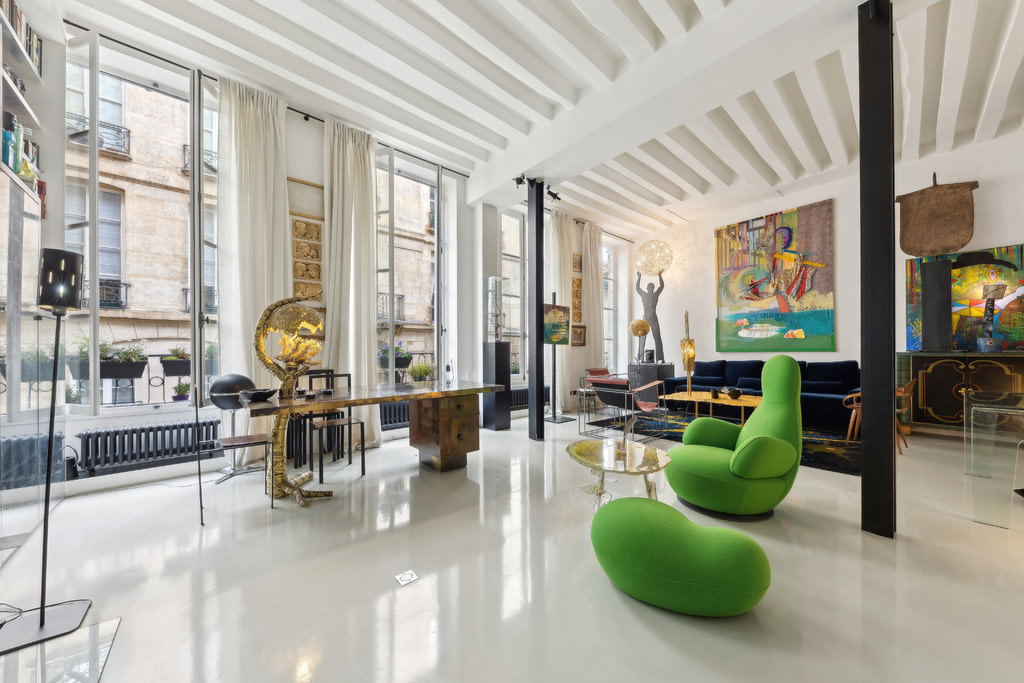Modern luxury apartment in Paris with green chairs.