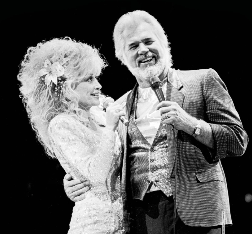 Dolly Parton singing on stage black and white
