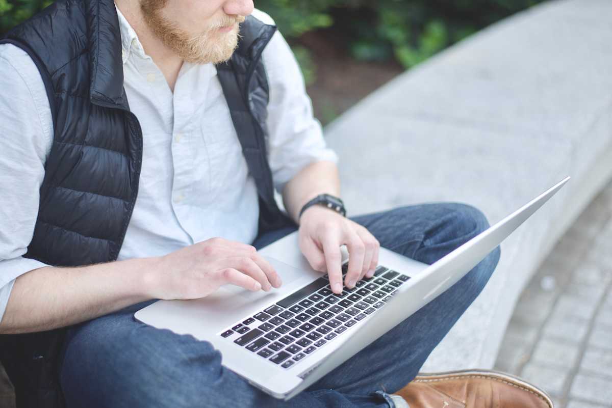 e-handel-trender-mynt Skäggig och välklädd man handlar på nätet via sin laptop.