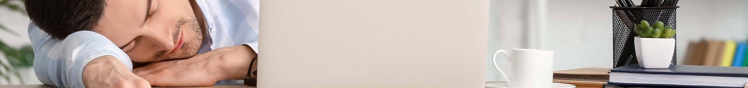 Person sleeping on office desk due to sleep deprivation