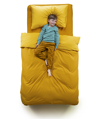 Top down view of a small boy laying on a kids bed in yellow.