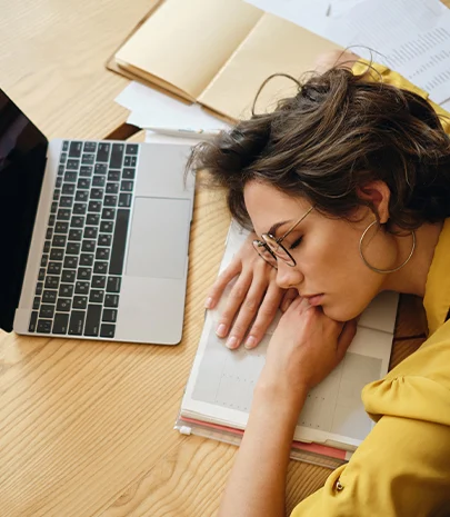 Tired person at work falling asleep at her desk