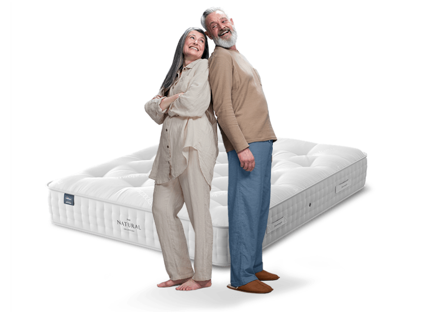 couple in pyjamas with mattress behind