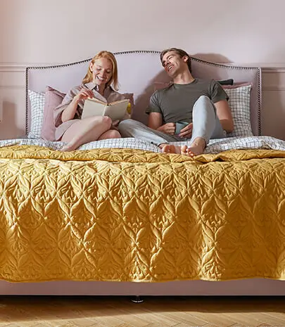 An adult couple on a divan bed