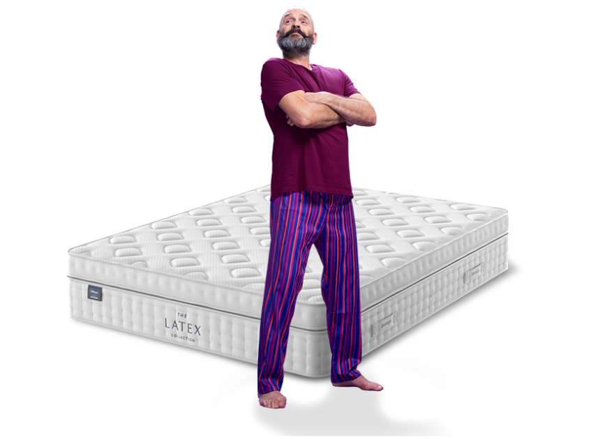 man in purple pyjamas with mattress behind