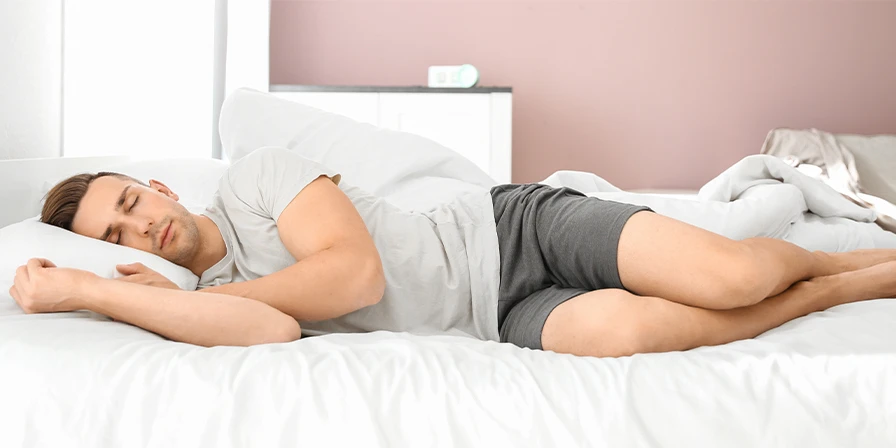 Man sleeping on his side in bed