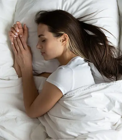 Woman in white asleep in bed