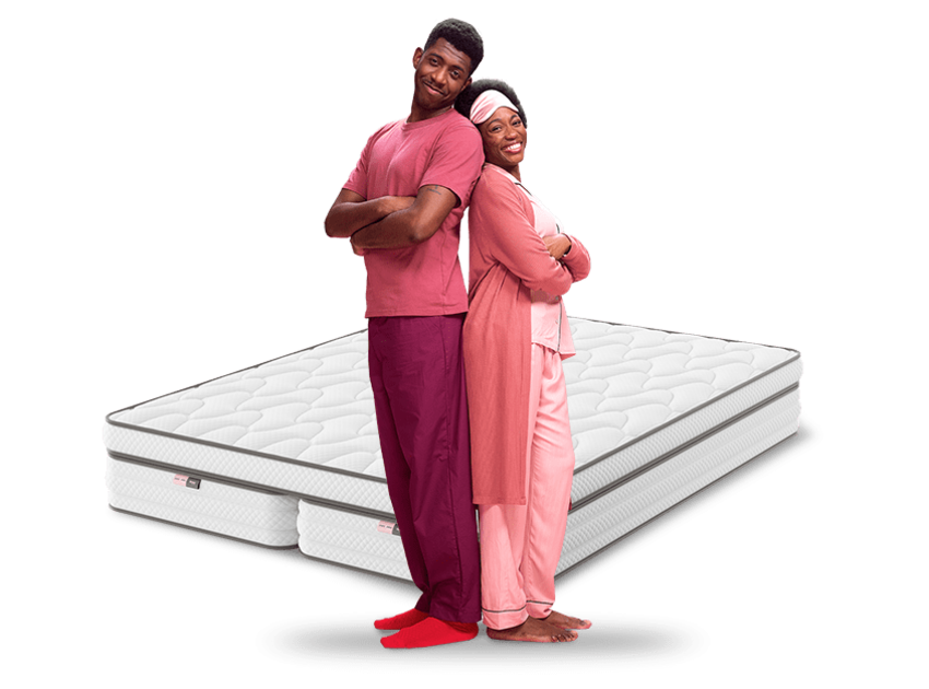 couple in pink pyjamas in front of mattress