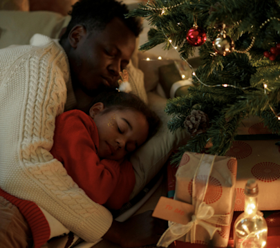 family sleeping at christmas by the christmas tree