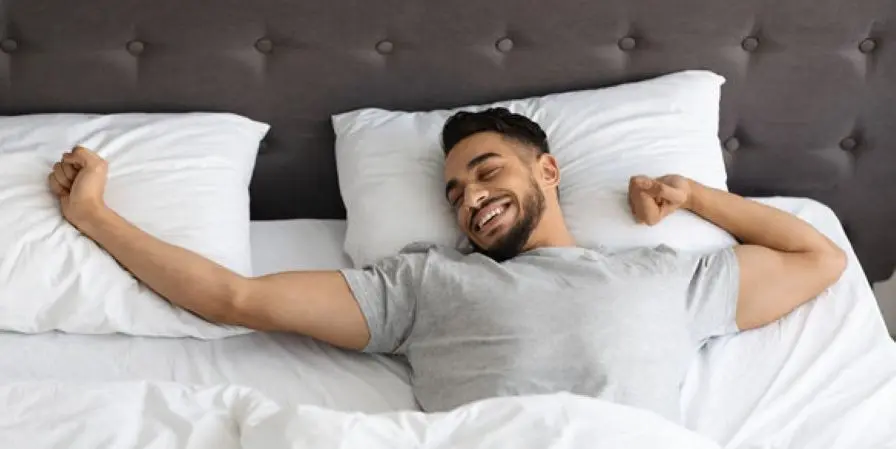 man sleeping happy in bed