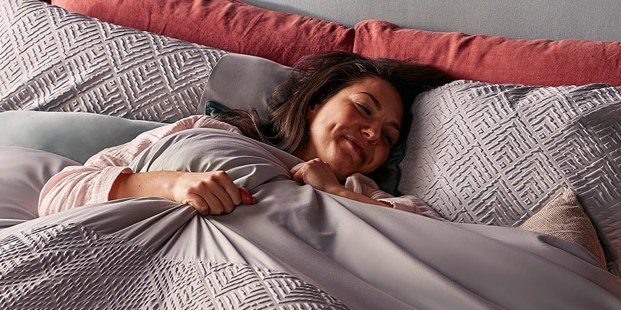Happy woman falling asleep in bed with a christmas theme