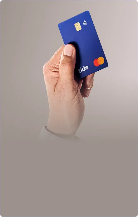 Hand holding Tide card - beige background