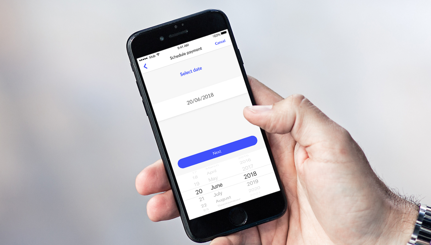 Hand holding a smartphone with a calendar on screen