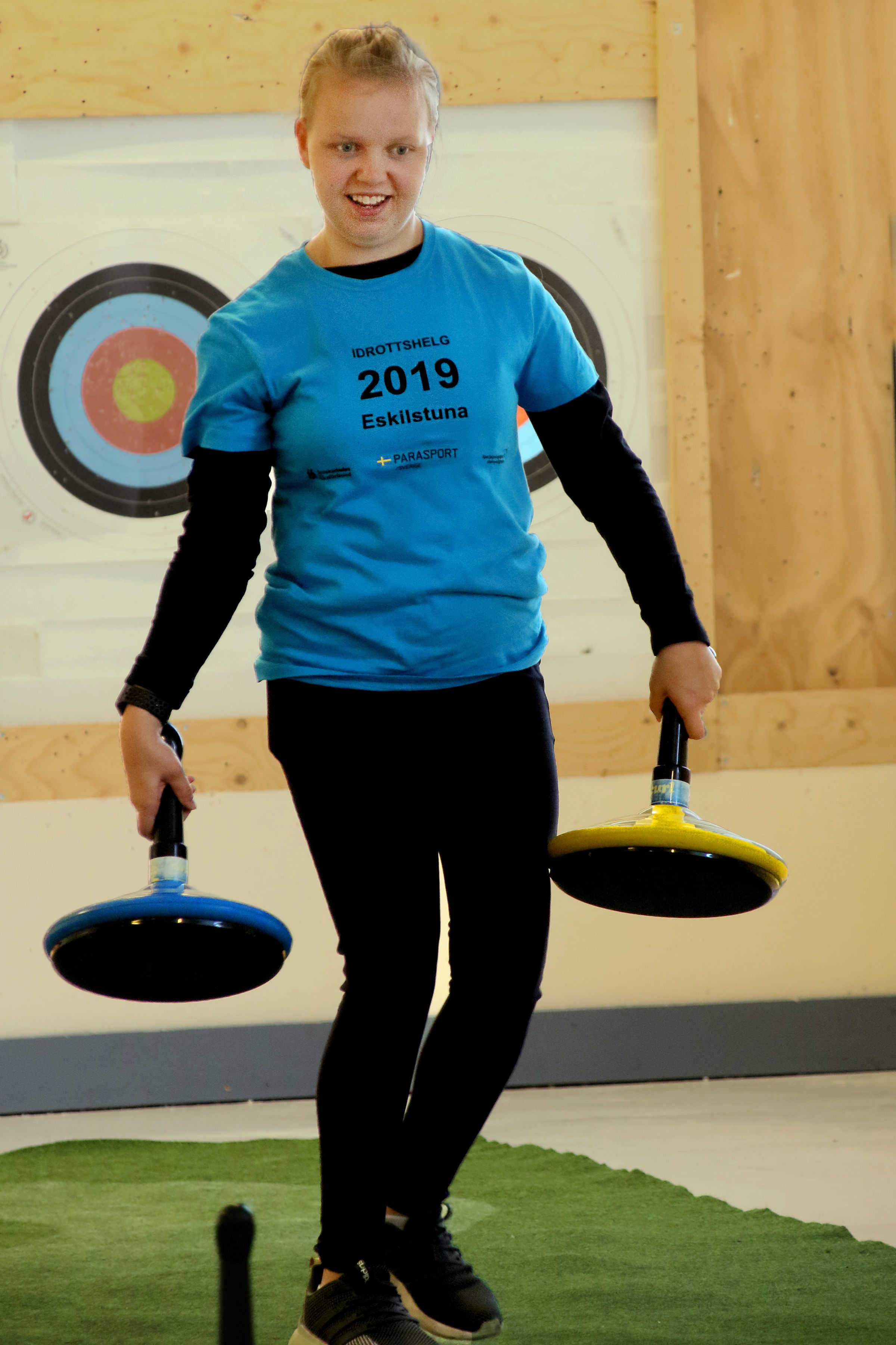 Flicka på väg att kasta iväg sin mattcurlingsten.