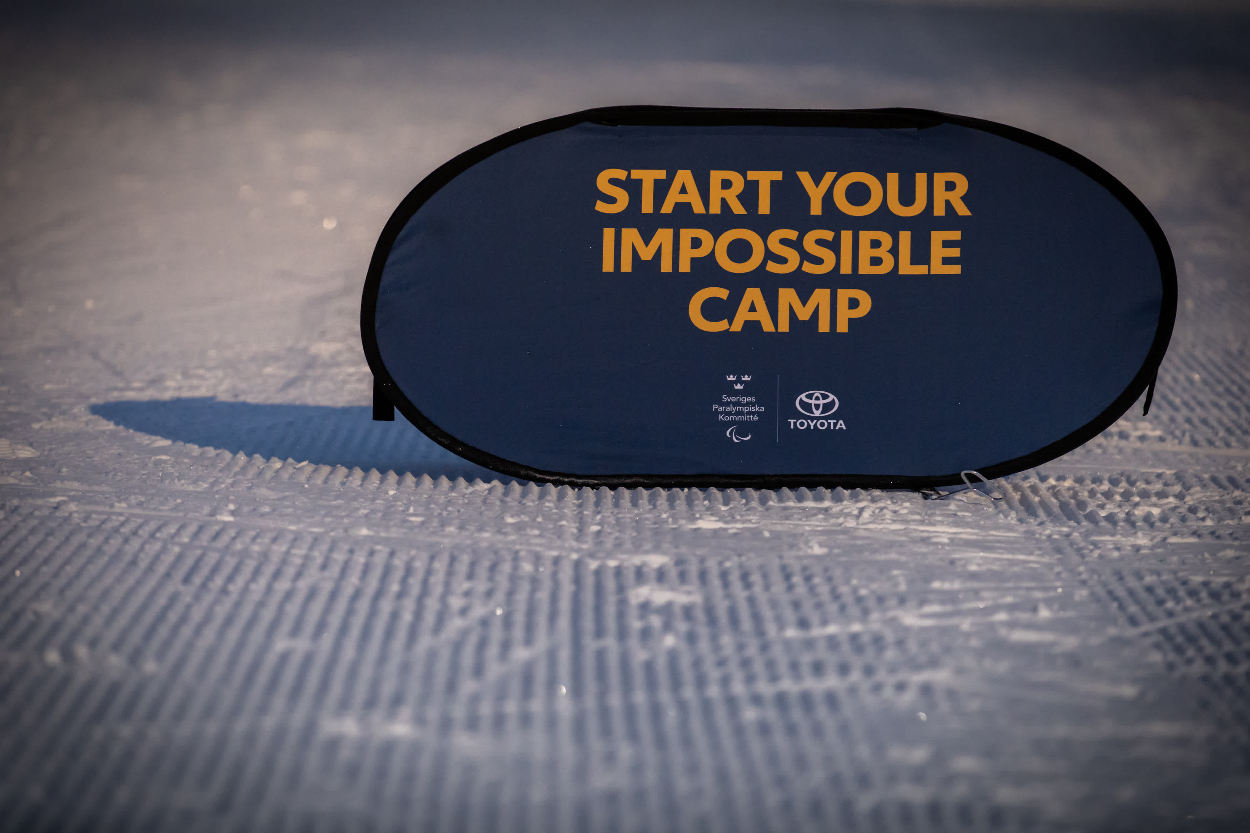 Start Your Impossible Camp skylt står ute i snö.
