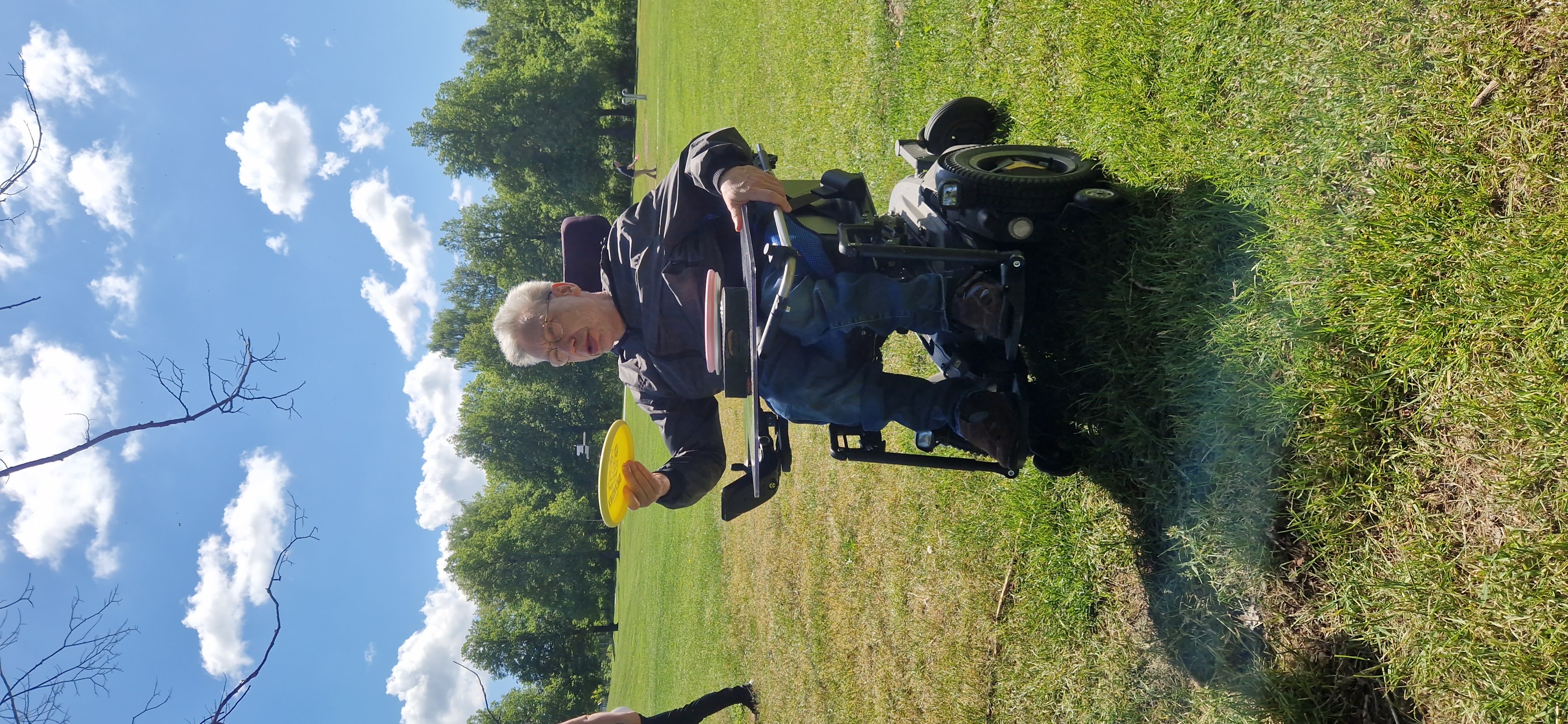 En person i rullstol kastar frisbee.