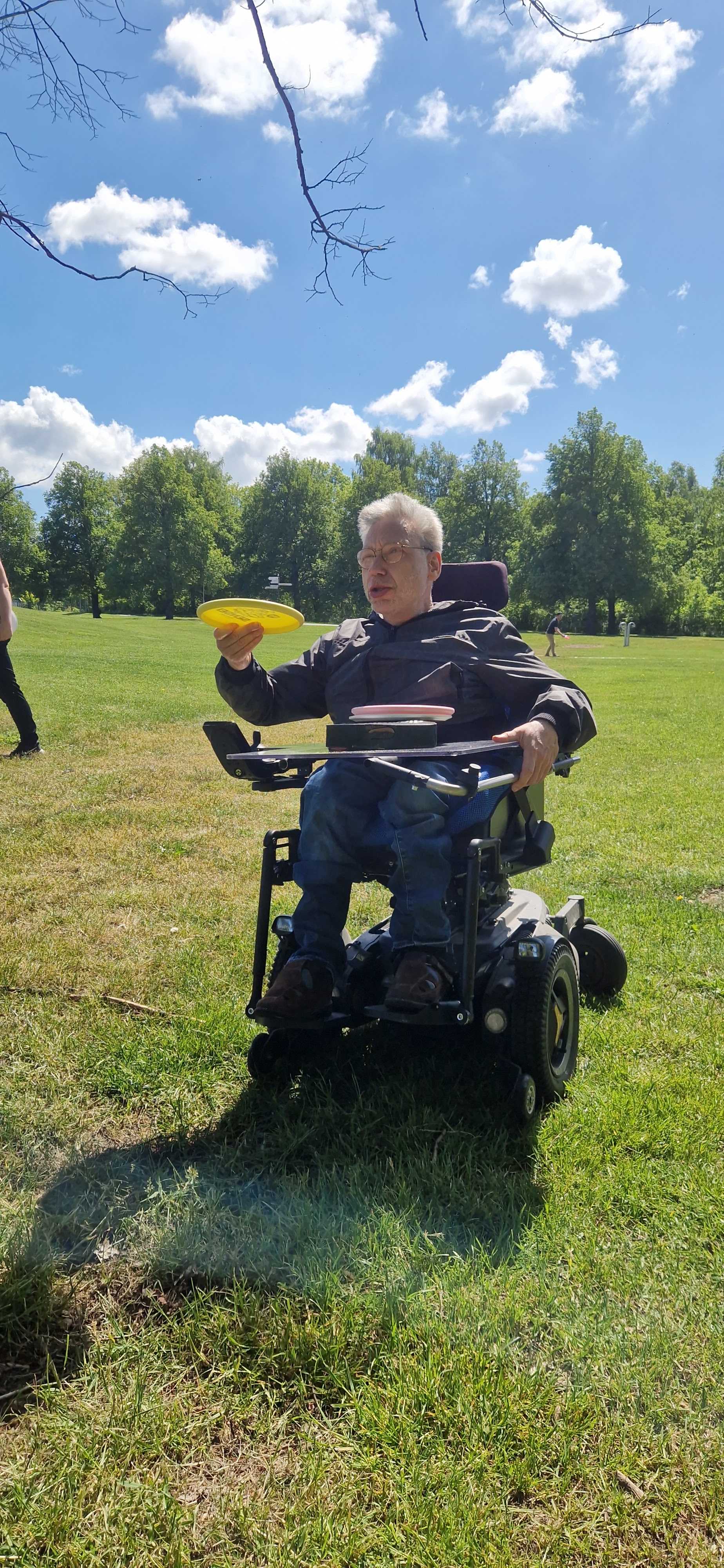 En person i rullstol kastar frisbee.