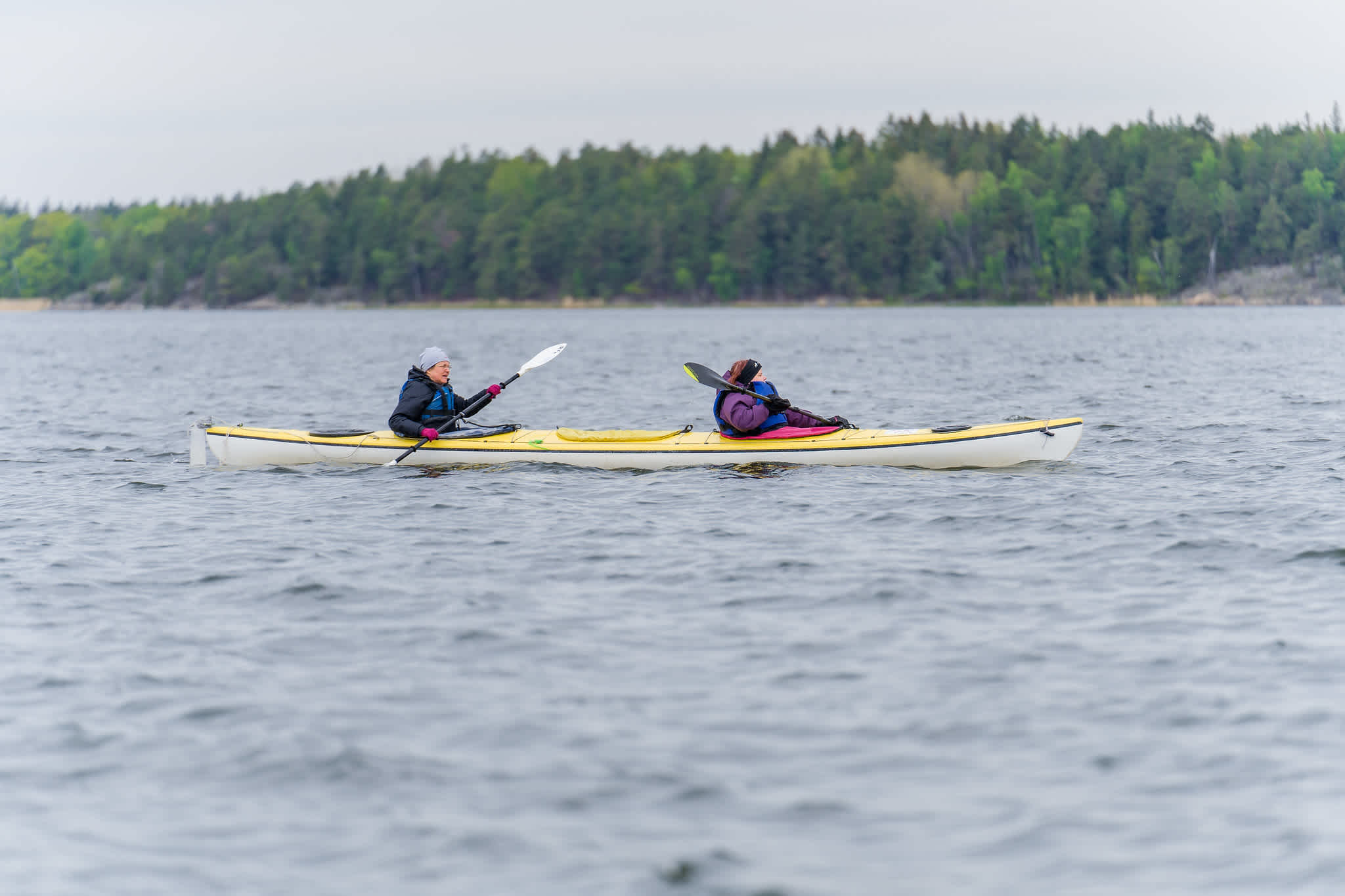 Dubbelkanot med två utövare ute på vattnet. Vädret är mulet och lite blåsigt. 