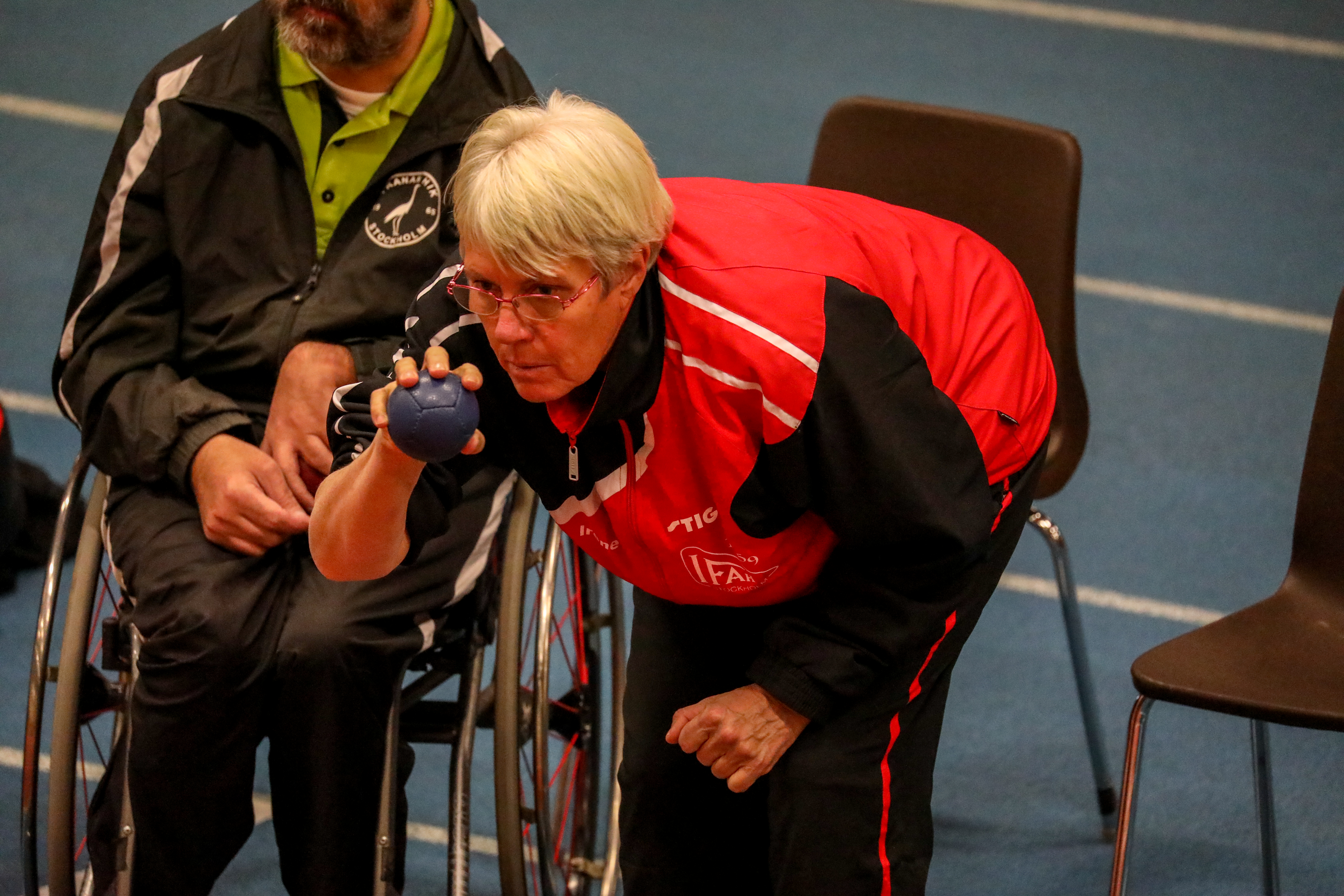 En äldre kvinna ska kasta iväg ett bocciaklot.