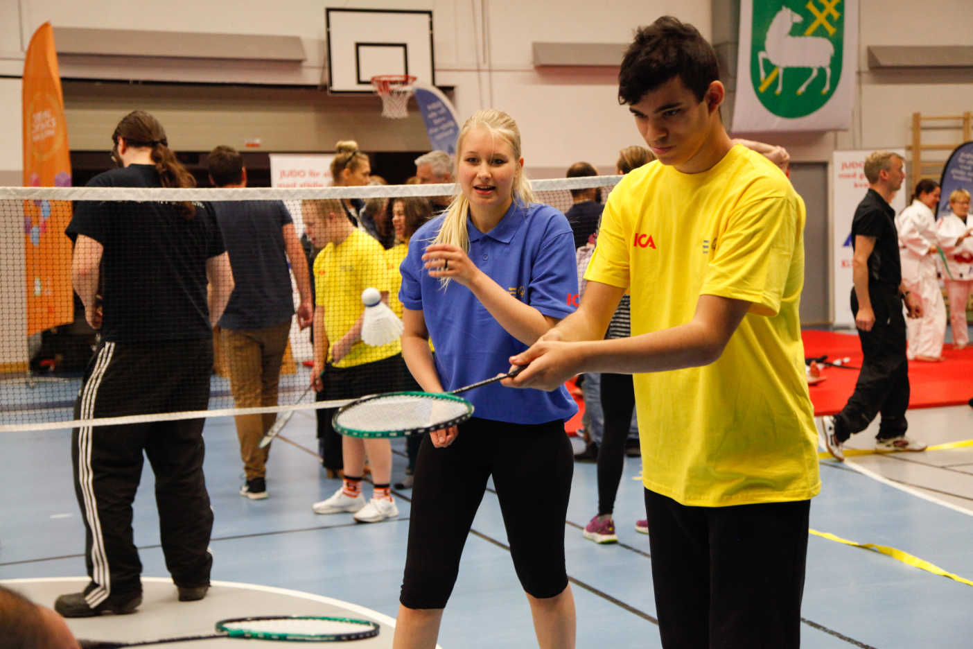 En ung man slår koncentrerat badmintonfjädern.