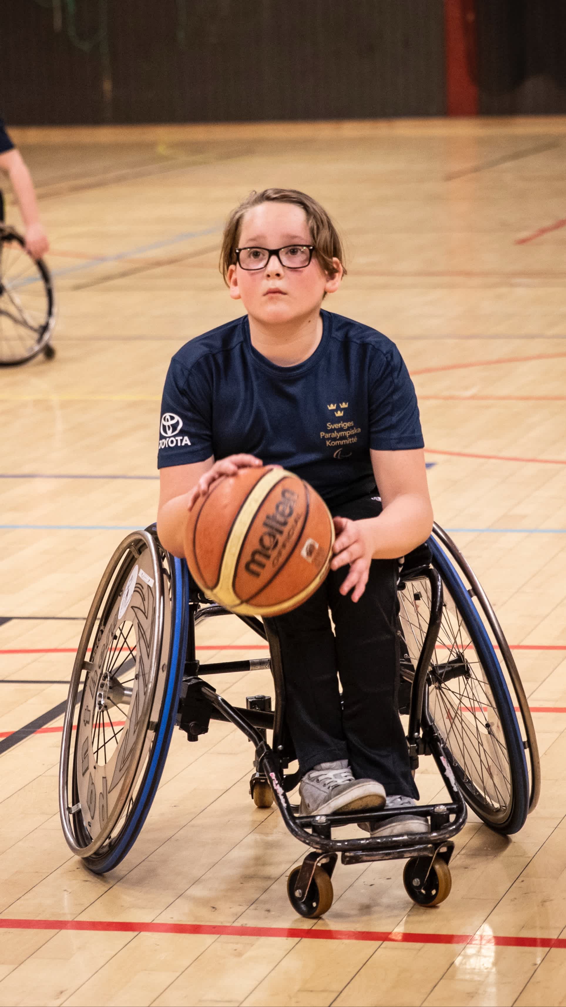 En ung pojke förbereder ett kast med basketbollen.
