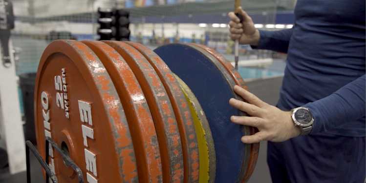Inomhusmiljö, gym. Närbild på viktskivor, stora stålskivor i olika färger.