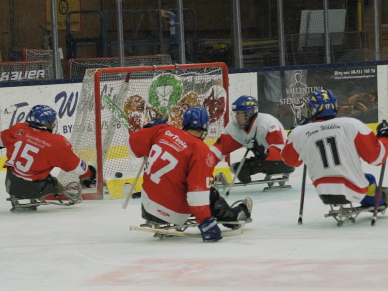 Fyra spelare kämpar om pucken framför det ena lagets mål.
