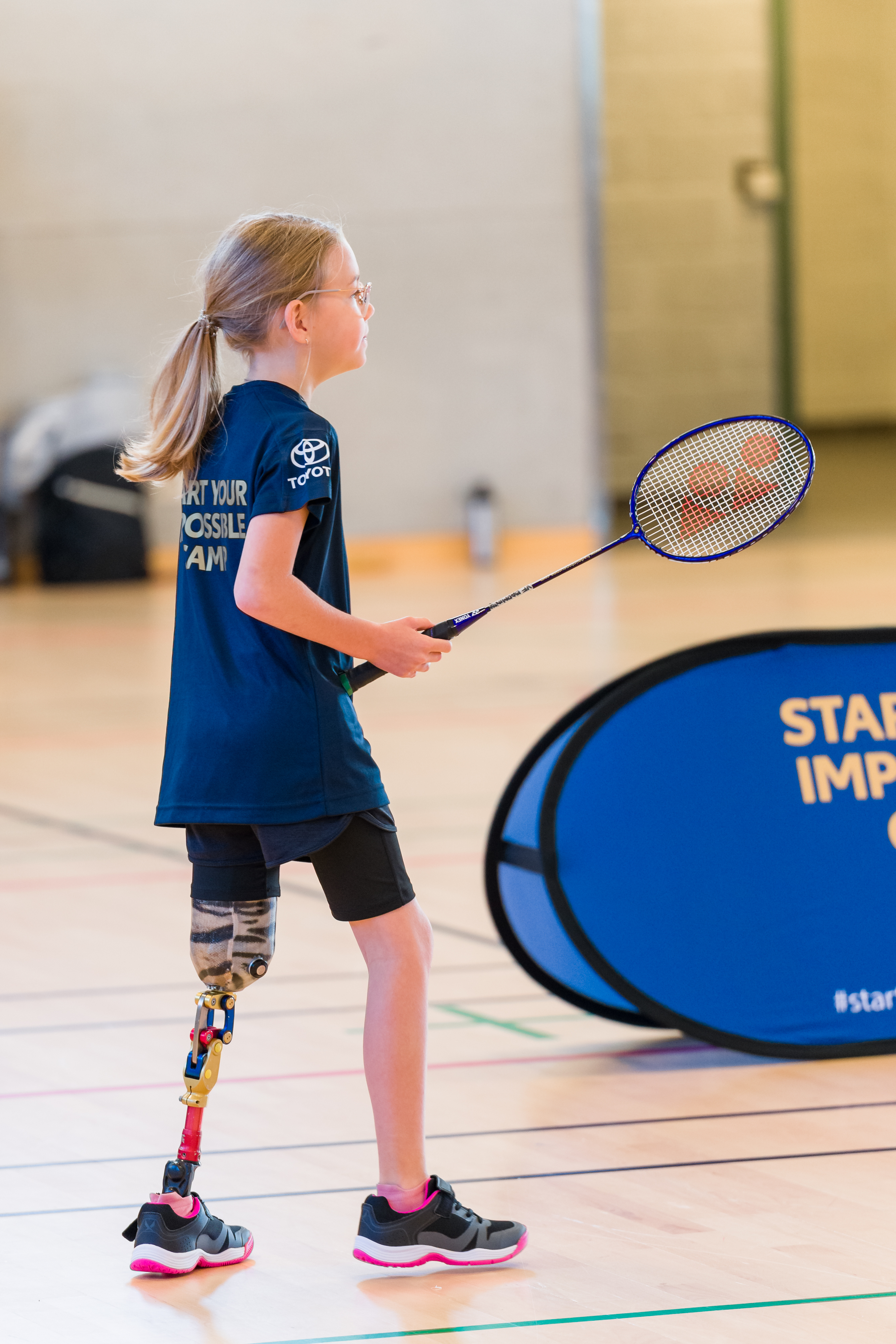 Flicka med benprotes står vi nätet och ska ta bollen.