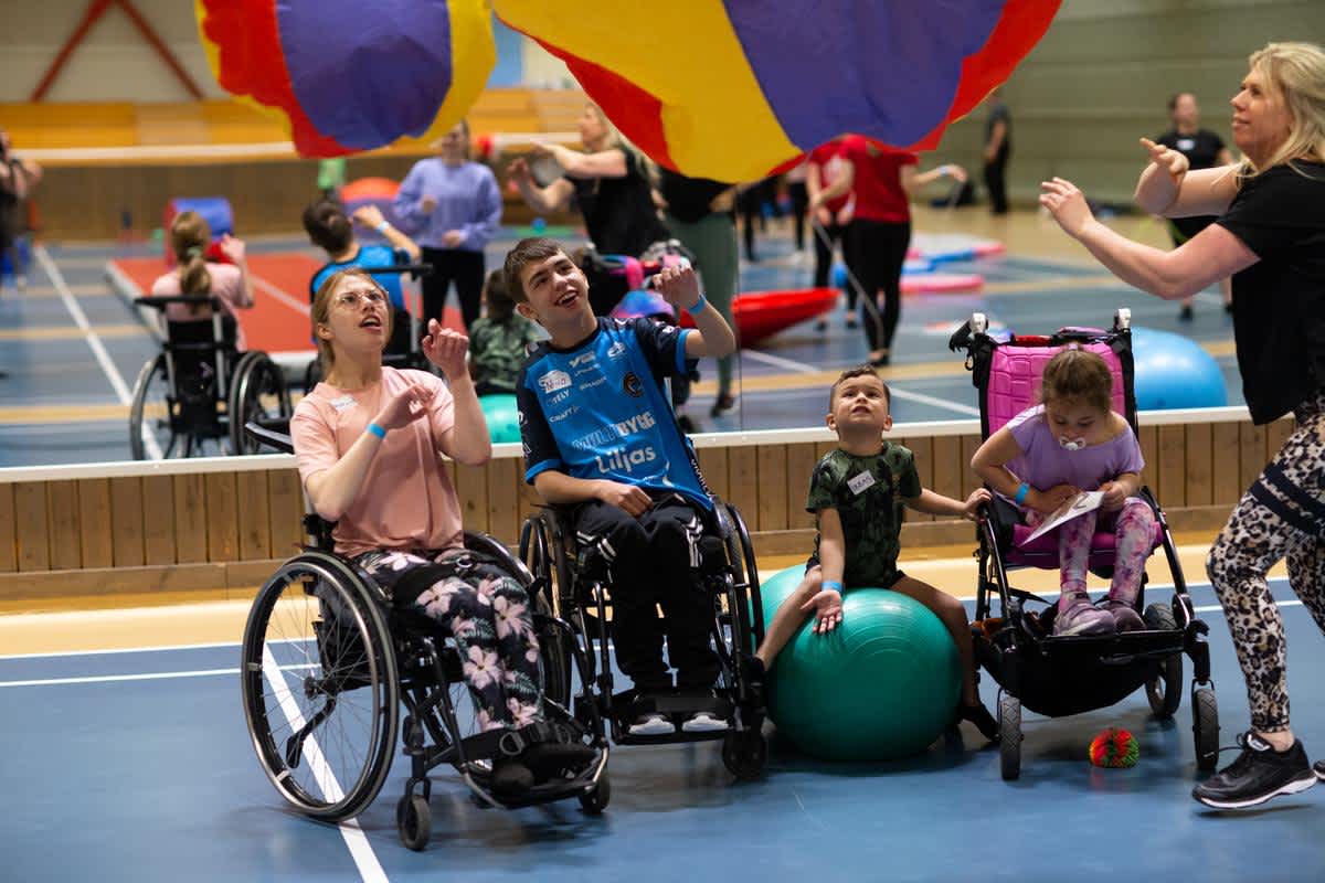 Flera personer i rullstol utövar gymnastik.