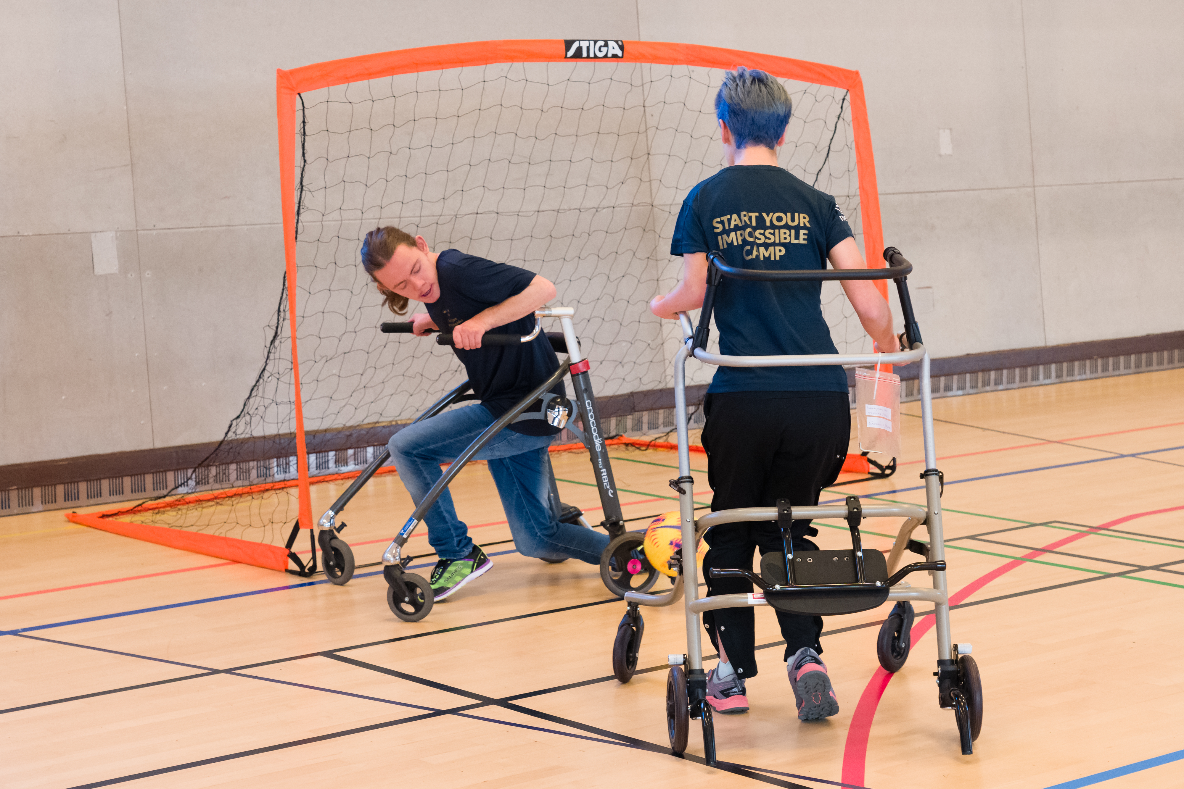 Två spelare vid mål, en spelare har precis skjutit bollen och den andra försöker blockera skottet.