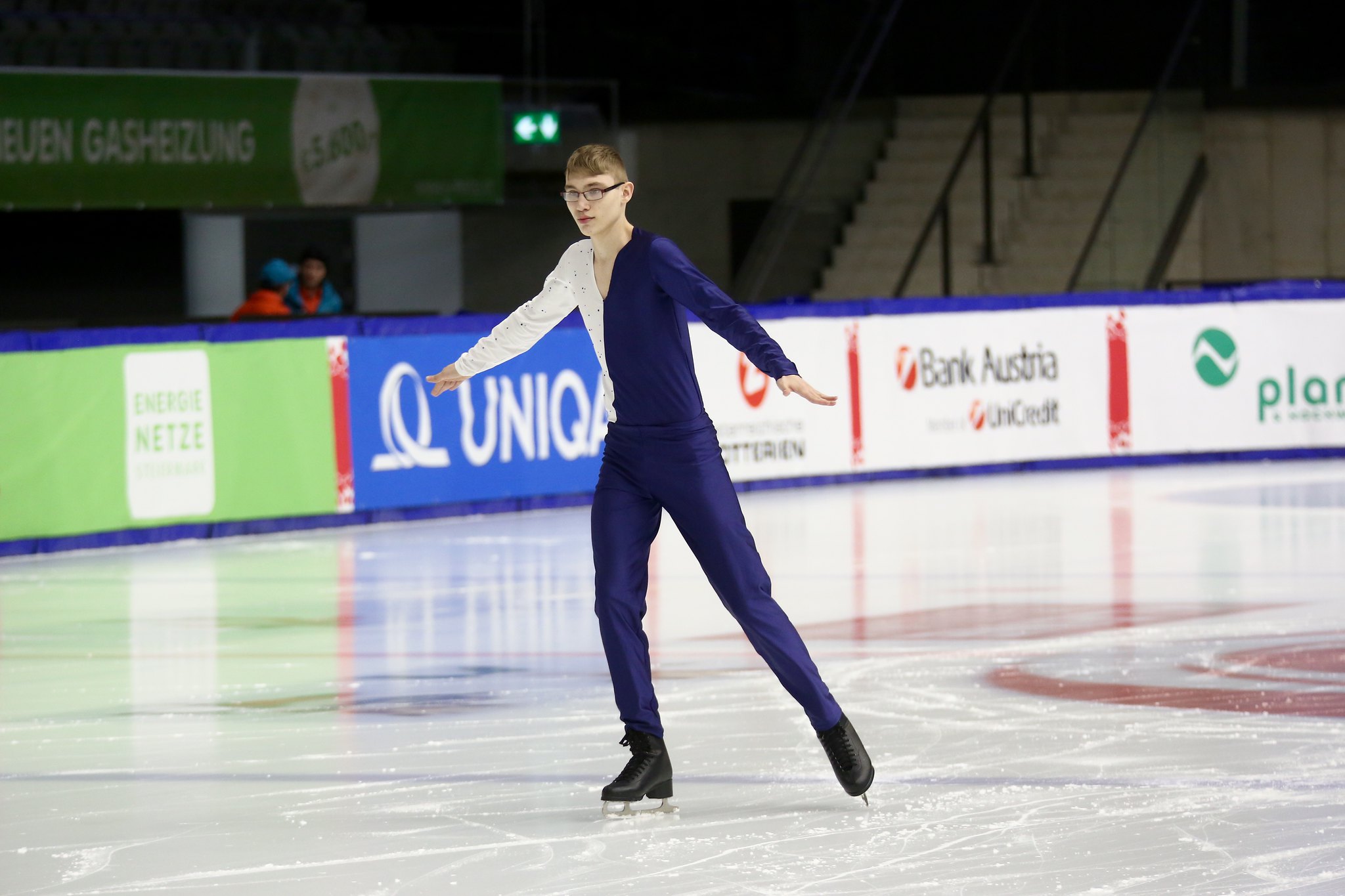 En kille på skridskor glider över isen när han har konståkningsuppvisning.