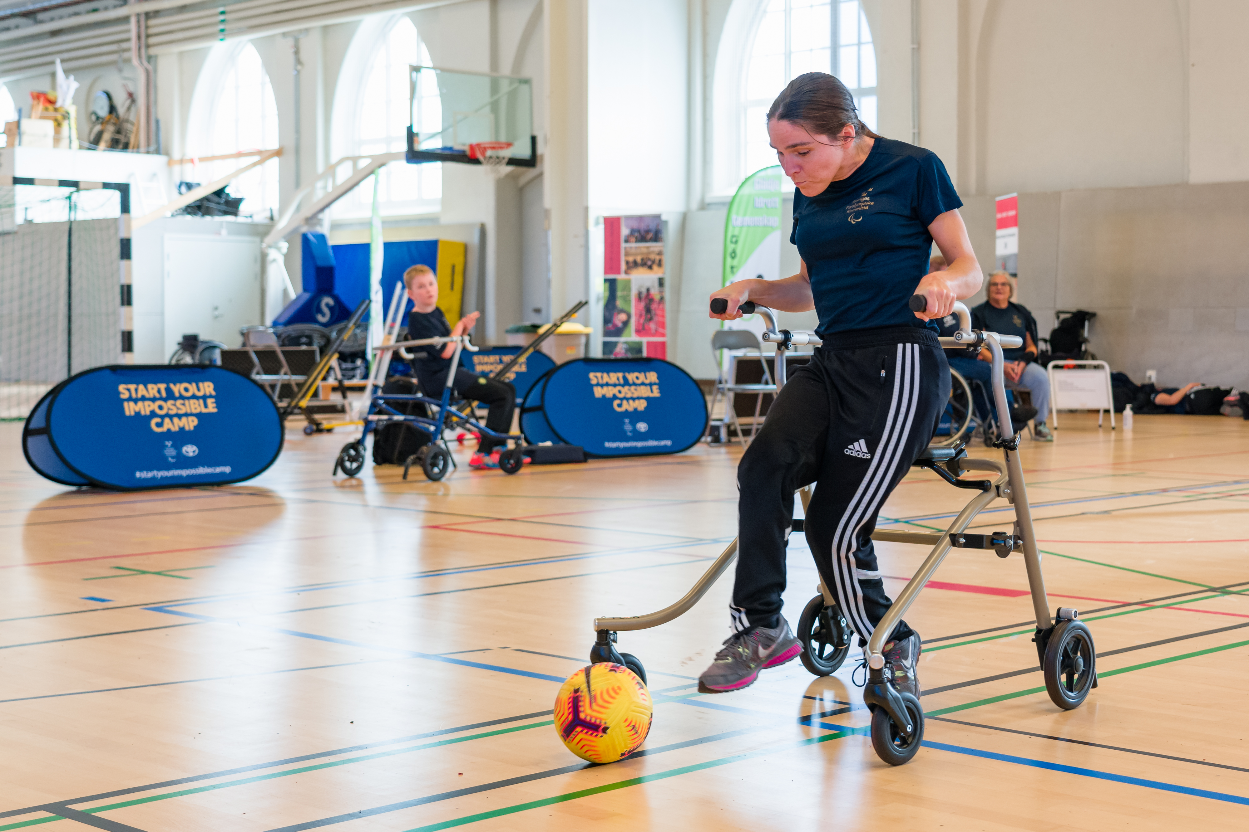 Ung kvinna med bollen framför fötterna.