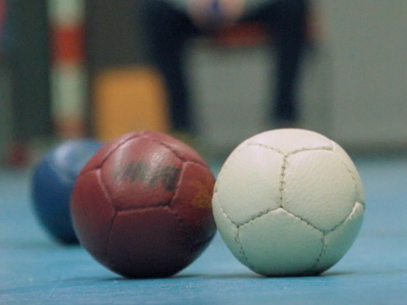 En vit, en röd och en blå boll ligger på den ljusblå mattan.