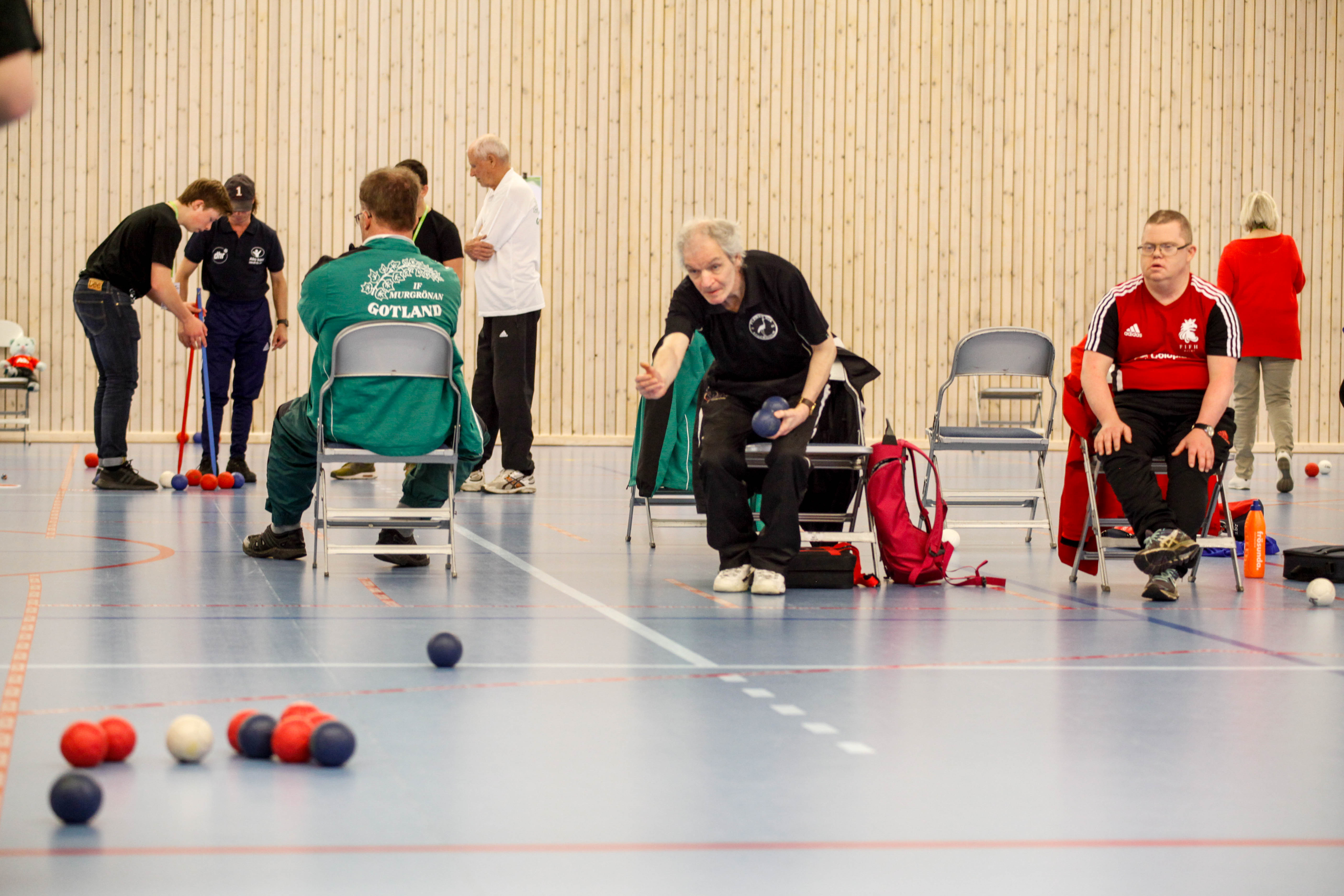 En äldre man kastar iväg bocciaklotet.