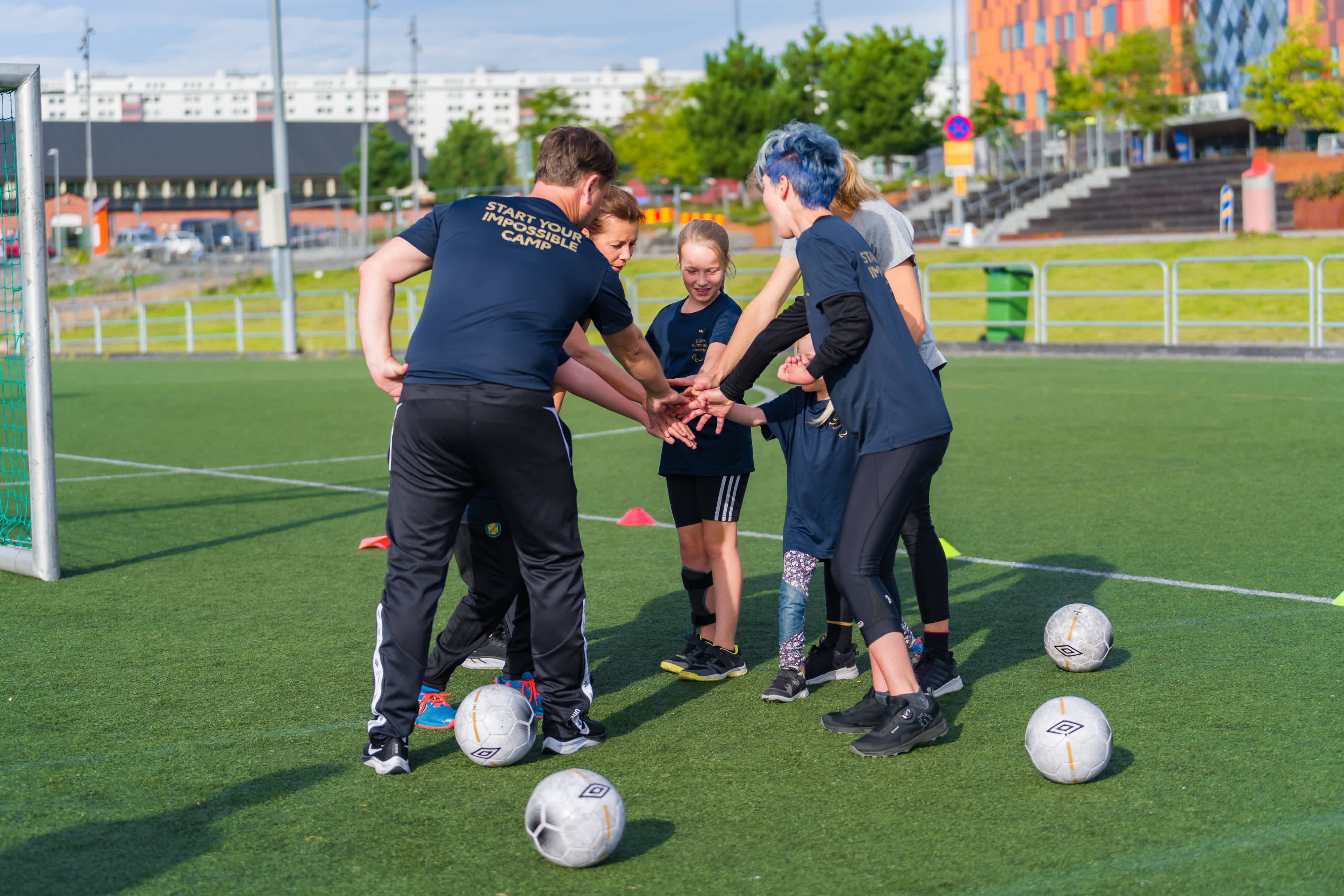 Spelare står i en ring med händerna i mitten för att peppa varandra innan spel.